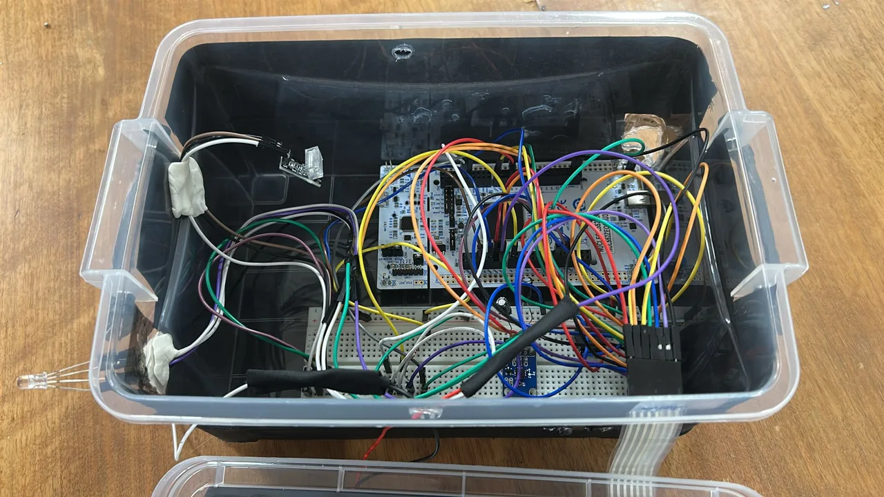 Inside the alarm enclosure: STM32 boards, breadboards, sensors, and jumper wiring.